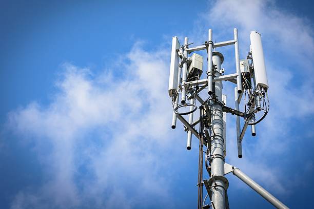 telecommunications tower with antennas on blue sky with cloud